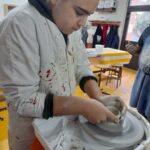 Un jeune homme fait de la poterie avec le tour de potier