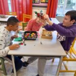 Trois jeunes font des constructions en lego