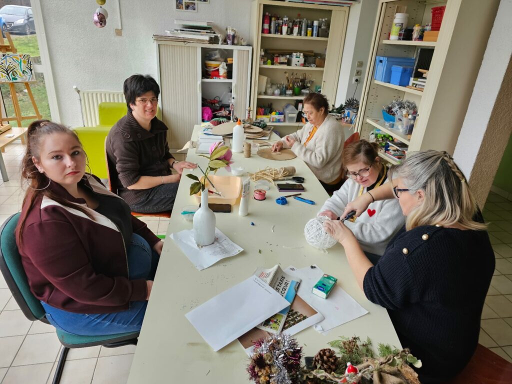 4 résidentes avec Sonia, autour de la table en pleine création