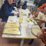 3 résidentes à table préparent et garnissent les crêpes