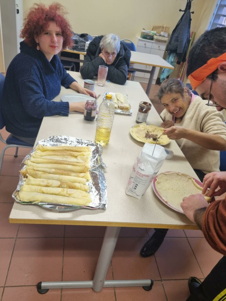 3 résidentes à table préparent et garnissent les crêpes