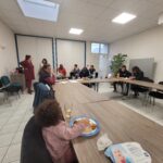 Personnes accompagnées et personnels échangent et mangent des crêpes autour de la table