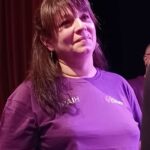 Béatrice, coordinatrice des Arts à l'APAJH Aude avec le tee-shirt du groupe