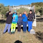 Les jeunes et leur encadrante devant le camion benne dans l'oliveraie