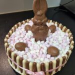Un gâteau constitué de fingers, chamallows, œufs et lapin en chocolat