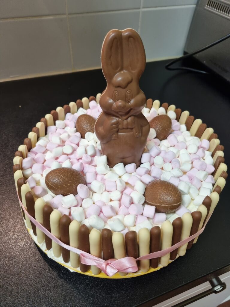 Un gâteau constitué de fingers, chamallows, œufs et lapin en chocolat