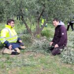 Deux personnes ramassent les branches coupées