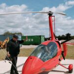 Deux jeunes dans le cockpit d'un hélicoptère avec un encadrant debout à leurs côtés