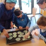 2 jeunes et 2 accompagnatrices font des muffins bleus en atelier cuisine