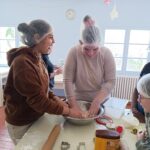 Deux jeunes filles préparent la pâte sablée sous le regard des autres enfants