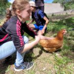 3 jeunes dans le poulailler avec les poules