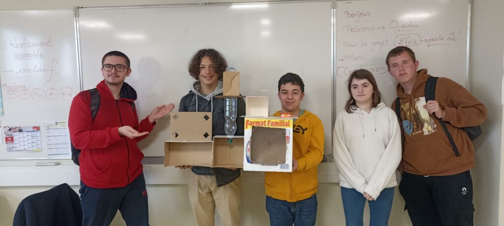 Le groupe pose avec sa maquette devant le tableau