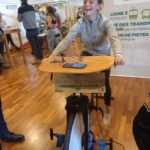 Une jeune fille de l'IME, sur un vélo, pédale pour produire de l'énergie