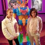 Deux jeunes posent devant une figurine de Goldorak