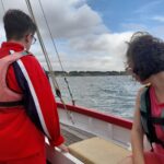 Deux jeunes de dos et profil sur le voilier