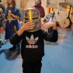 Au premier plan un petit garçon de l'UEE avec un heaume. En arrière plan des personnes en tenues d'époque