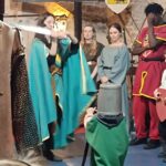 En tenues d'époque, un jeune chevalier se fait adouber