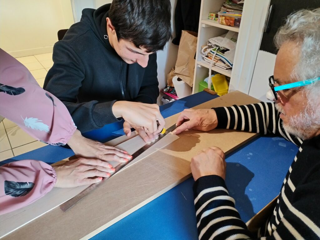 Un jeune et un parrain autour d'une table construisent un avion
