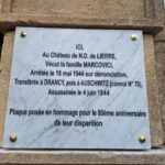Gros plan sur la plaque commémorative sur laquelle il est inscrit :"Ici, au château de Notre Dame de Lierre, vécut la famille Marcovici, arrêtée le 18 mai 1944 sur dénonciation, transférée à Drancy, puis à Auschwitz (convoi 75), assassinée le 4 juin 1944. Plaque posée en hommage pour le 80ème anniversaire de leur disparition".