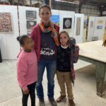 Deux jeunes filles avec Elena regardent des toiles