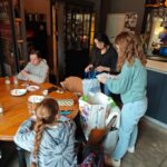 Les jeunes, au restaurant le Bastion, ouvrent les cadeaux achetés suite à la soirée caritative