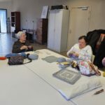 Magali et 3 autres adhérentes tricotent autour d'une table