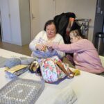 Magali tricote à côté d'une autre adhérente de l'association.