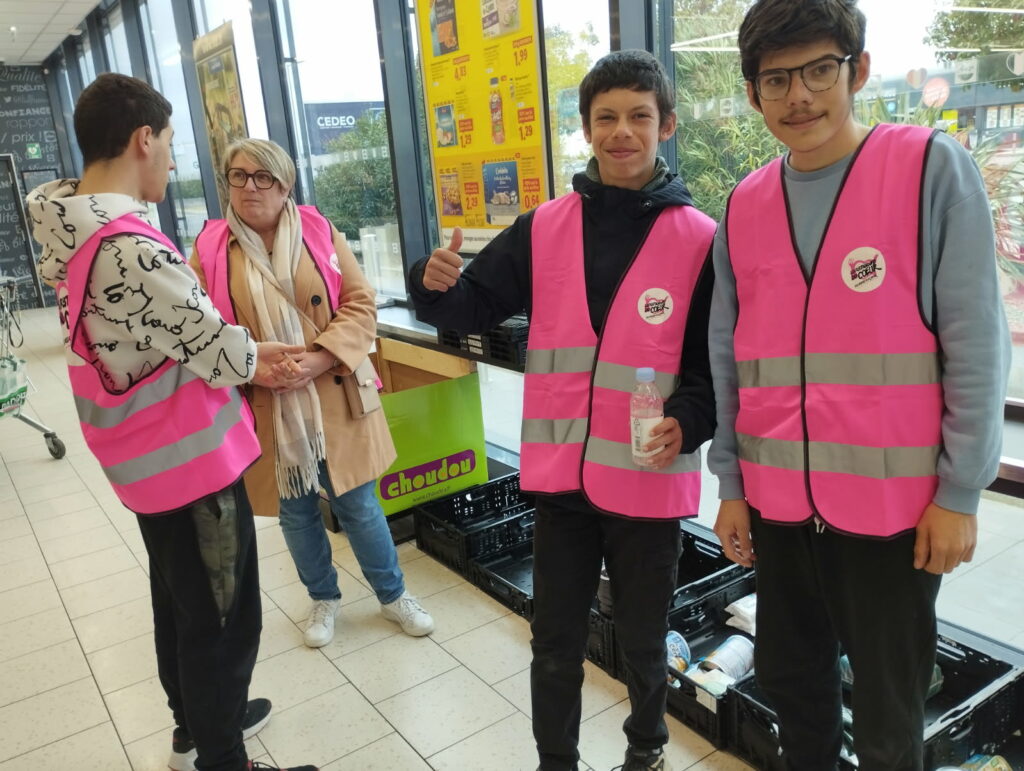 Trois jeunes, avec une bénévole, récupèrent les denrées collectées