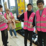 Trois jeunes, avec une bénévole, récupèrent les denrées collectées