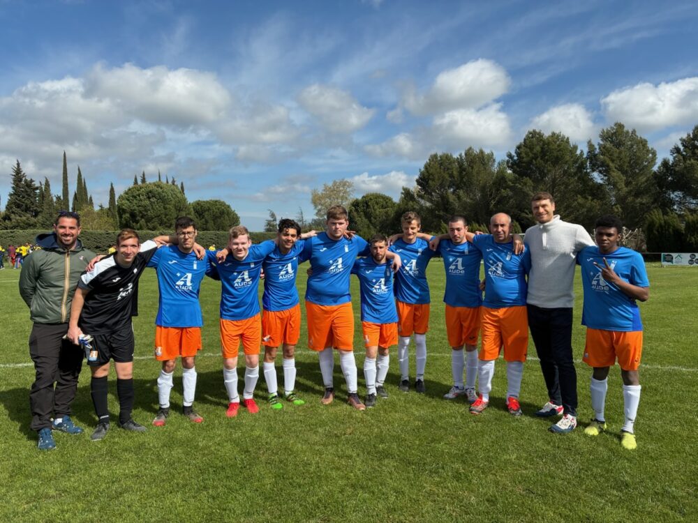 Photo de l'équipe sur la pelouse du terrain de foot, avec leur entraineur Laurent Azaïs et le directeur de l'ESAT, Nicolas Mongereau