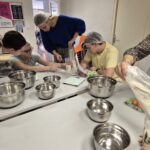 Les jeunes et leurs accompagnatrices autour de la table cuisinent