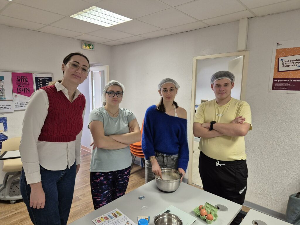 Photo de groupe avec 3 jeunes et une accompagnatrice devant une table