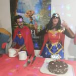 4 personnes derrière le buffet qui présente le dessert. Elles sont déguisées en : minion, superman, wonder woman, Mario Bros
