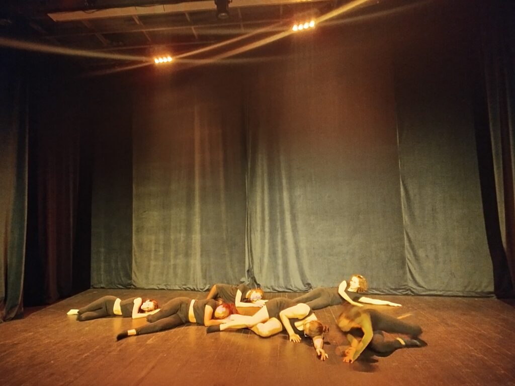 6 membres de la troupe, sur scène, couché