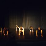 6 membres de la troupe, sur scène, accroupis