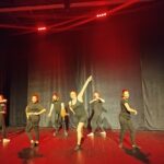 6 membres de la troupe, sur scène, habillés en noir