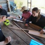 2 jeunes et un accompagnateur construisent un nouvel avion miniature