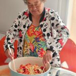 Une résidente remue la salade de fruits