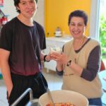 Deux personnes posent avec le plat de salade de fruits