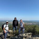 Trois personnes posent dans le massif des Albères. En arrière plan, panorama sur Argelès-sur-Mer.