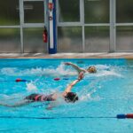 Deux personnes font une course en crawl dans deux couloirs différents.