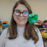 Une jeune de fille, de face, avec une fleur confectionnée dans les cheveux