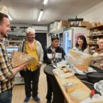 Dans l'épicerie de Marc, professionnels et personnes accompagnées du SAMSAH dégustent les fromages avec le patron de l'épicerie