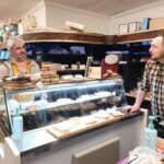 Dans l'épicerie de Marc, professionnels et personnes accompagnées du SAMSAH dégustent les fromages avec le patron de l'épicerie