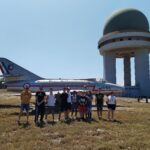 Photo de groupe devant un avion et le radar
