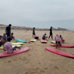 Les jeunes, sur leurs planches, sur le sable, en formation étoile.