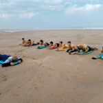 Les jeunes, en rang, allongés sur leurs planches face à l'océan