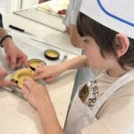 Un jeune garçon dépose la pâte dans un moule