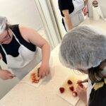 2 jeunes filles coupent des fraises