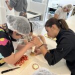 2 jeunes et Elona remplissent un fond de tarte